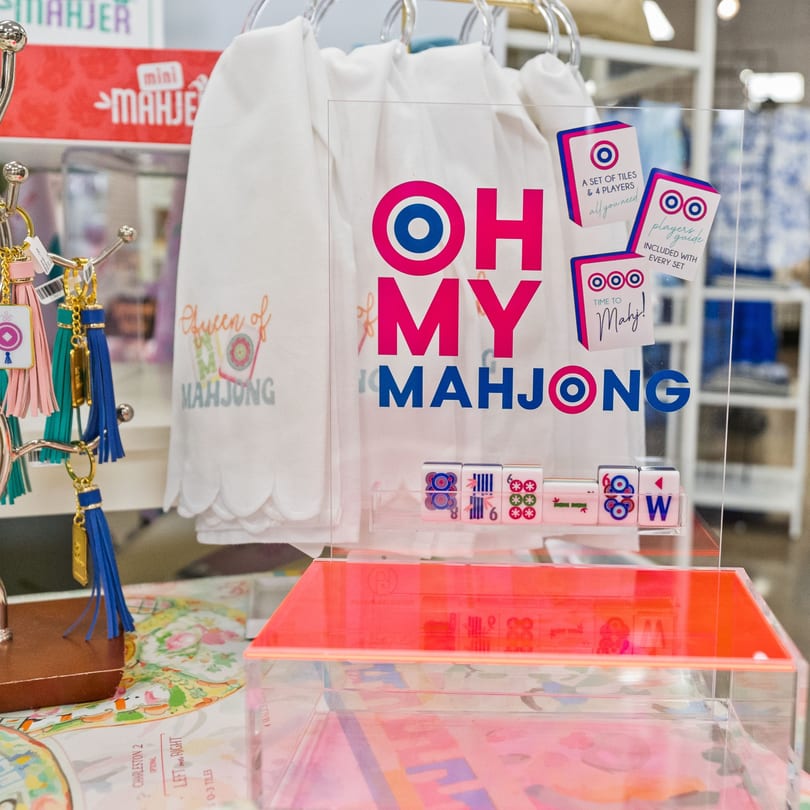 A clear acrylic sign with "OH MY MAHJONG" in pink and blue, displaying Mahjong tiles and keychains.