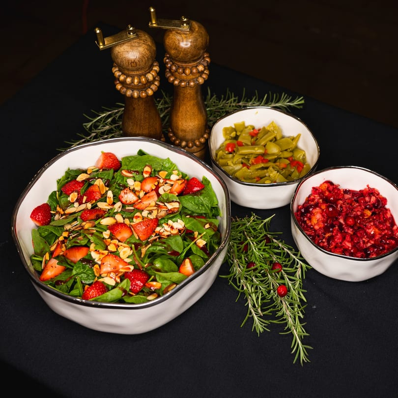 Strawberry spinach salad, green beans, and cranberry relish with wooden salt and pepper shakers.